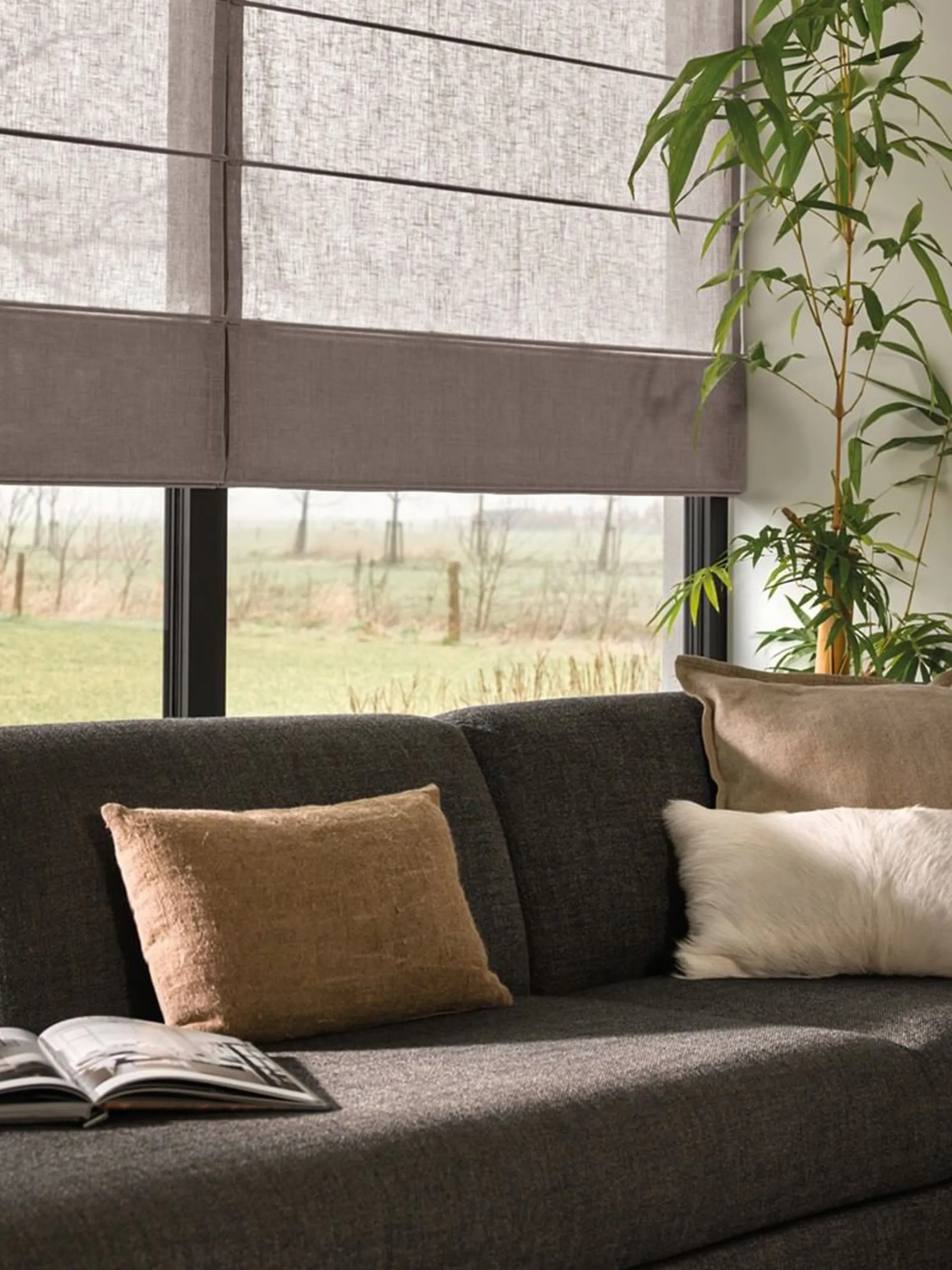 Roman blinds creating shadow on a sofa area.