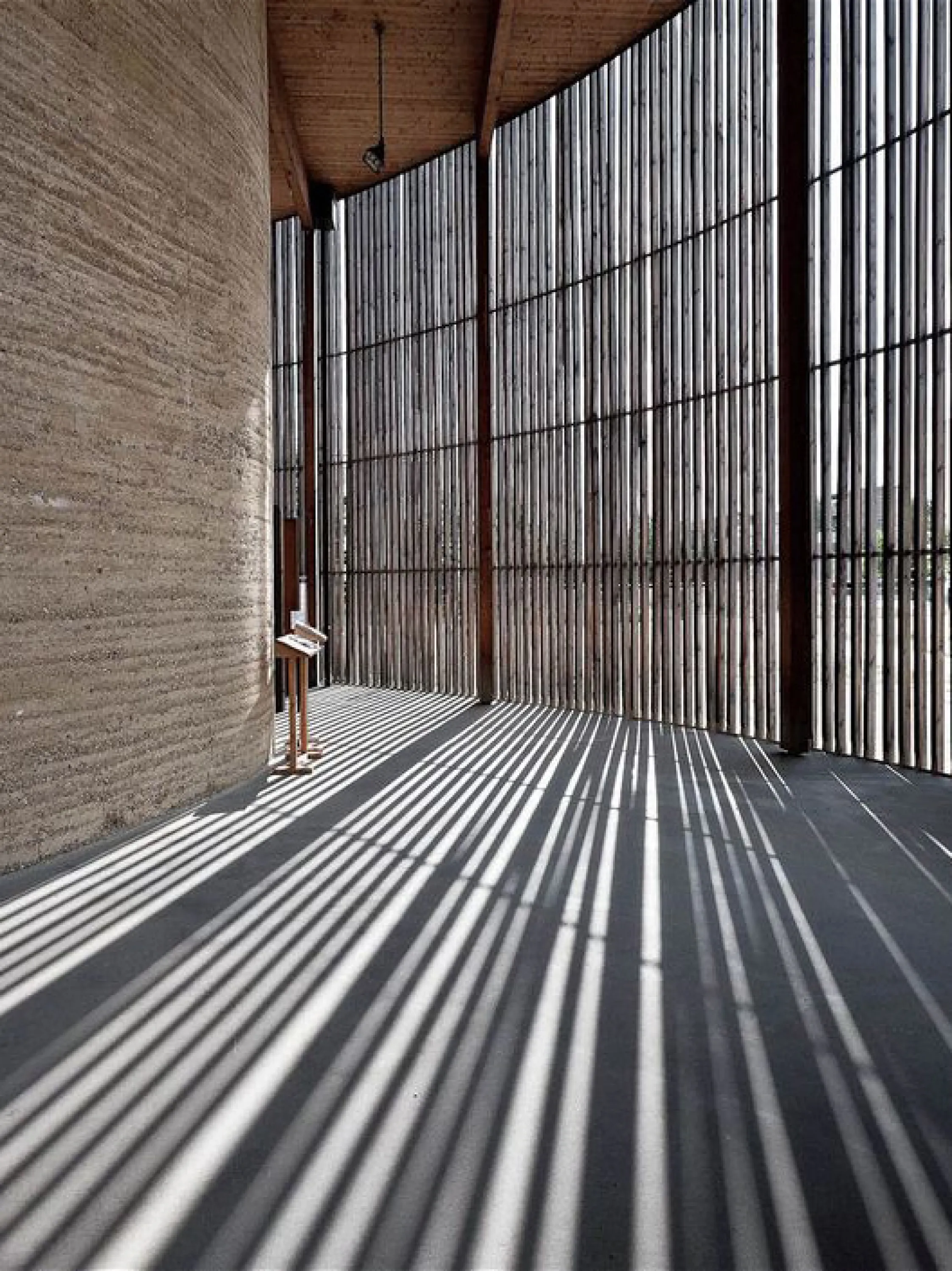 Sunlight drawing patterns by filtering through a ribbed partition.