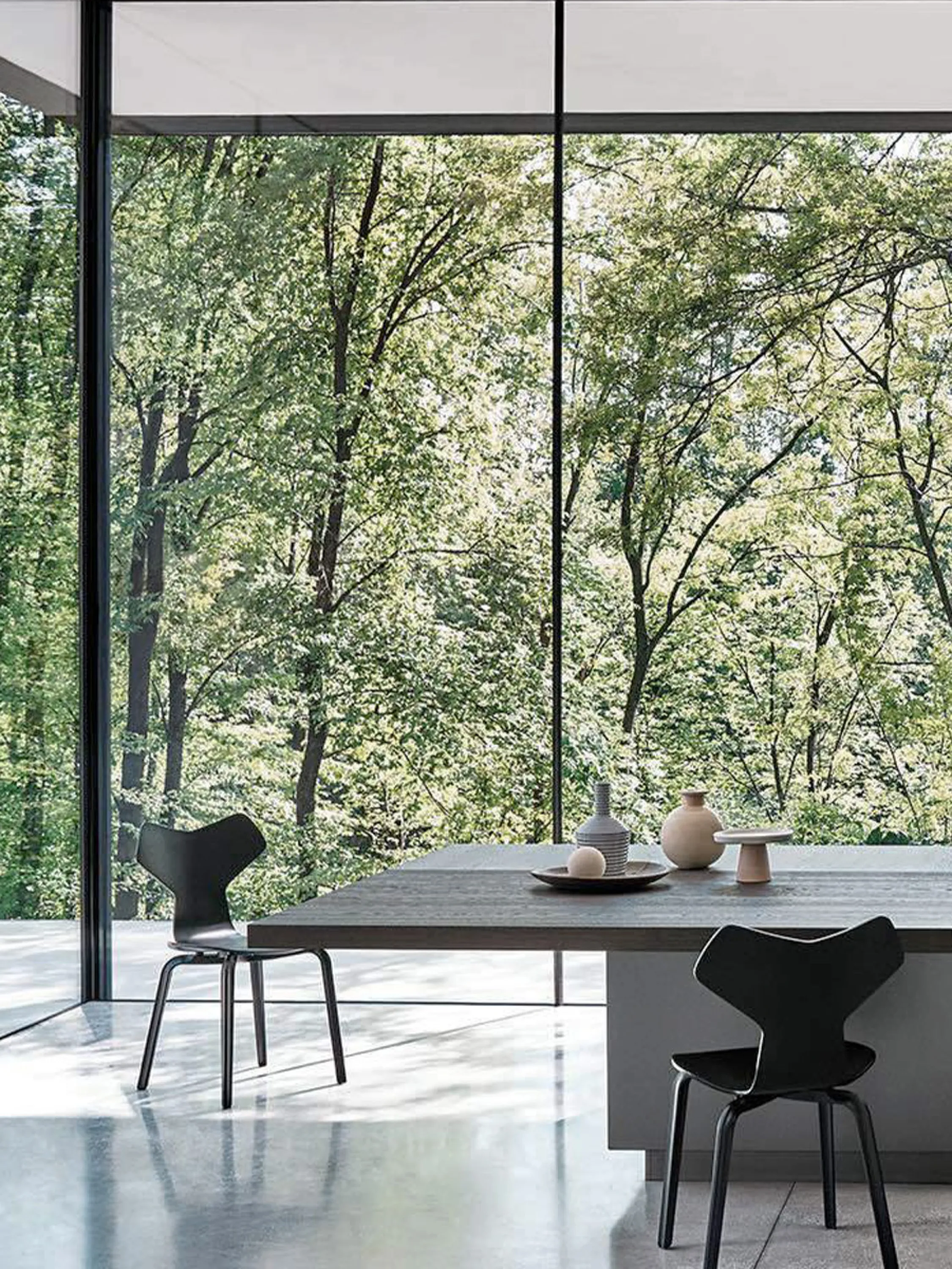 Kitchen with full-height windows and trees outdoors.