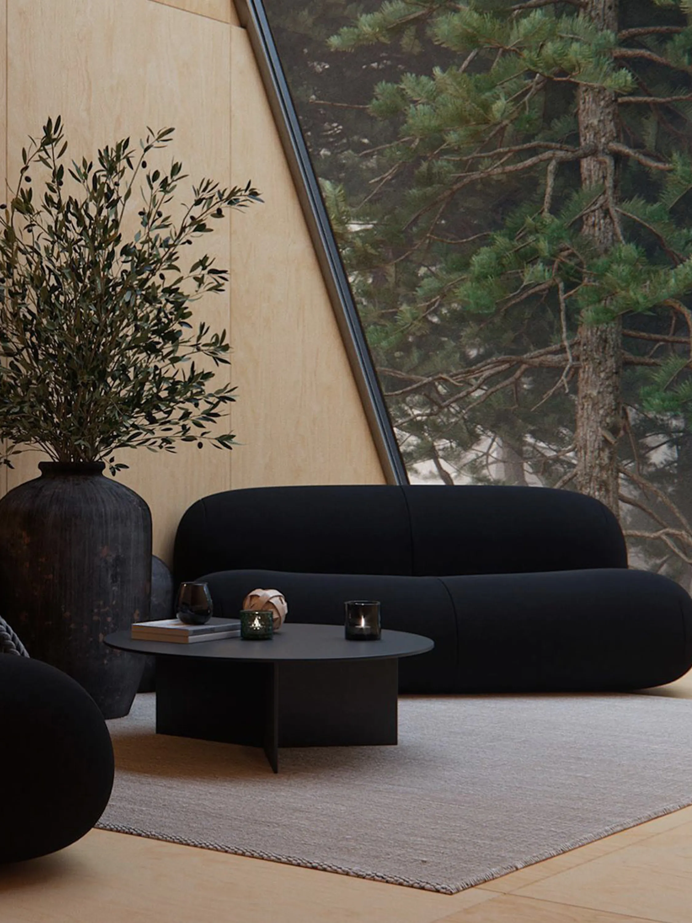 Living room with black furniture, wood walls and an open view onto the forest.