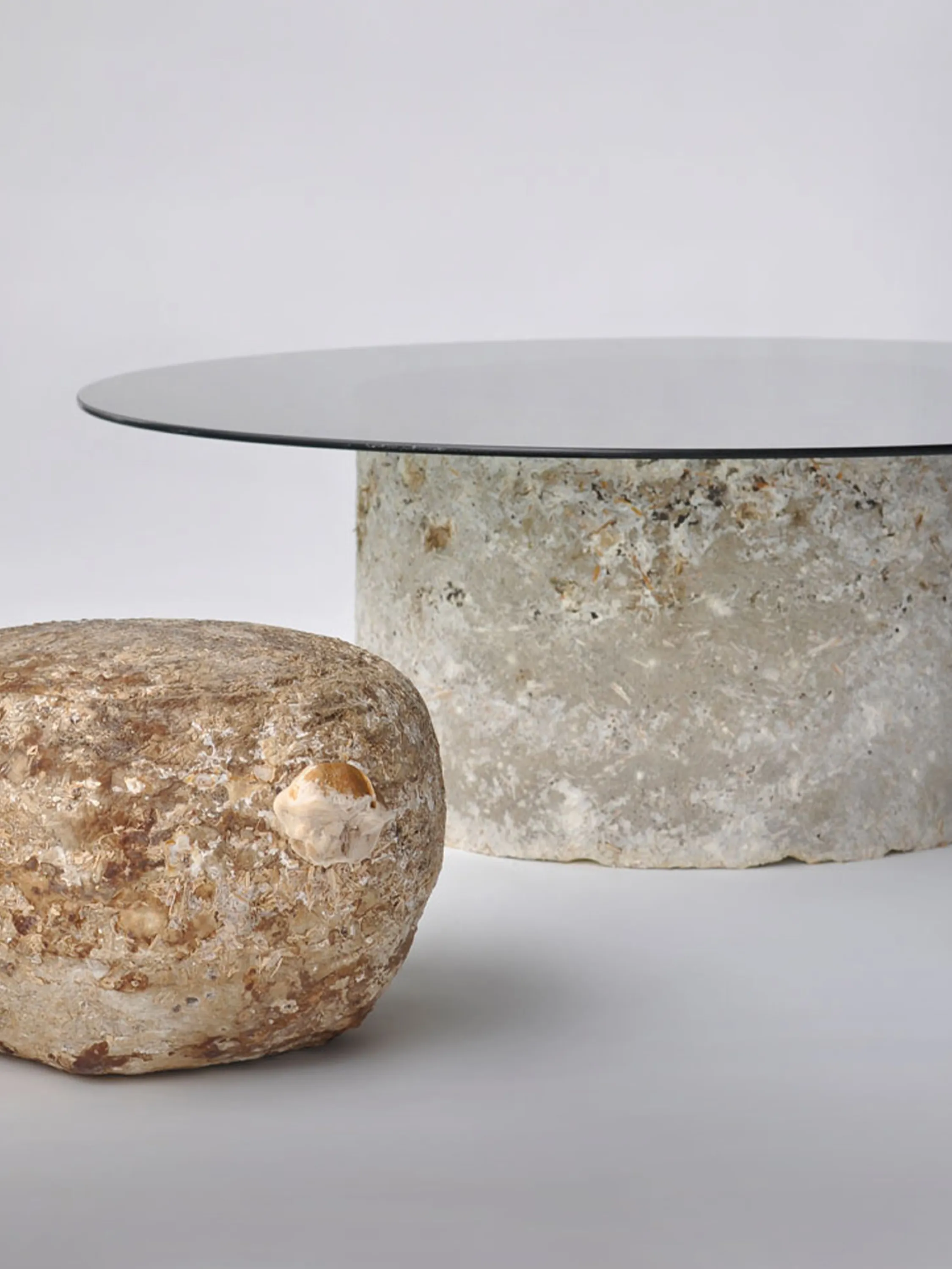 A round table with biofabricated base out of mycelium and glass top.