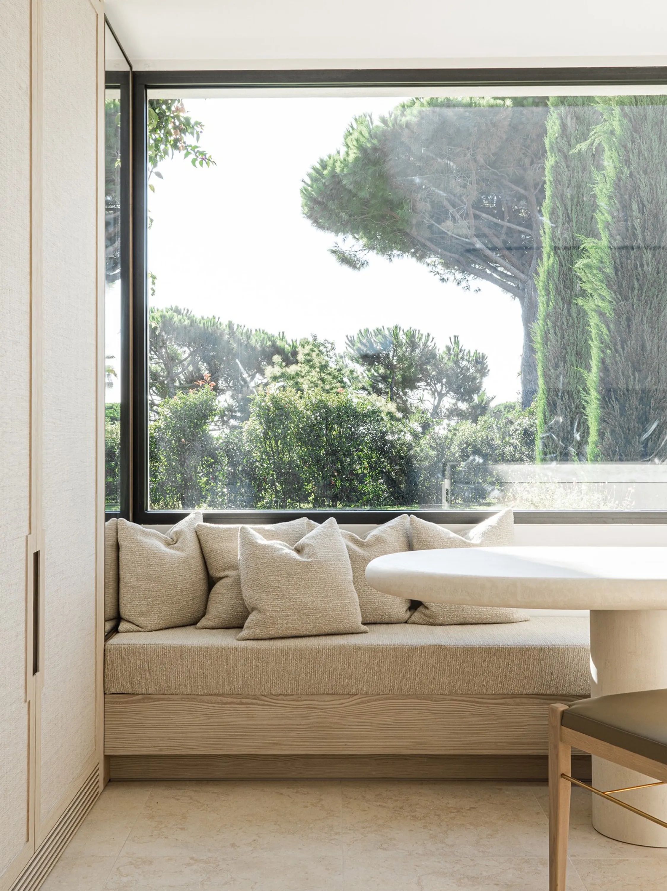 Window seat with view to a lush garden.