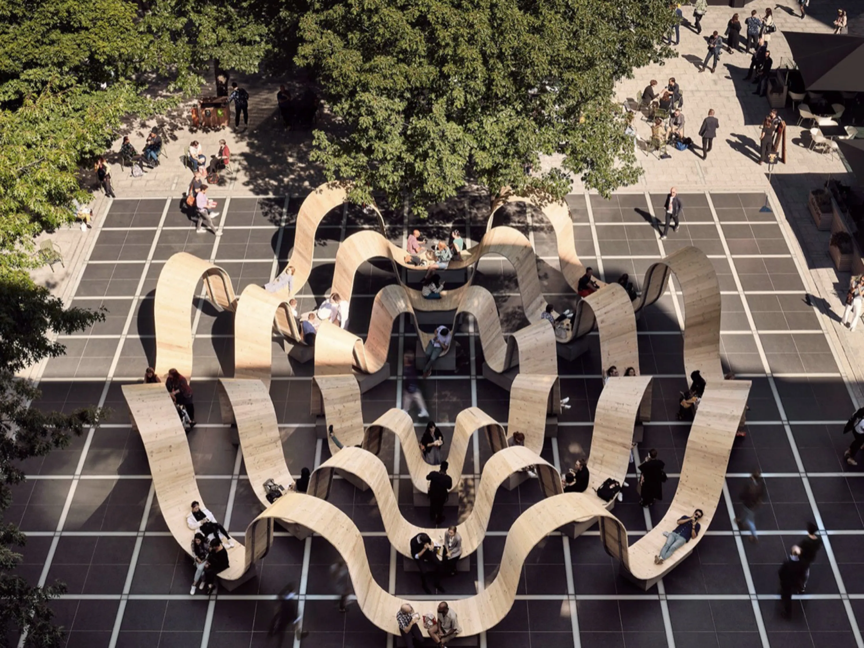 Bench with a curved profile that creates individual refuge areas for each person seating.