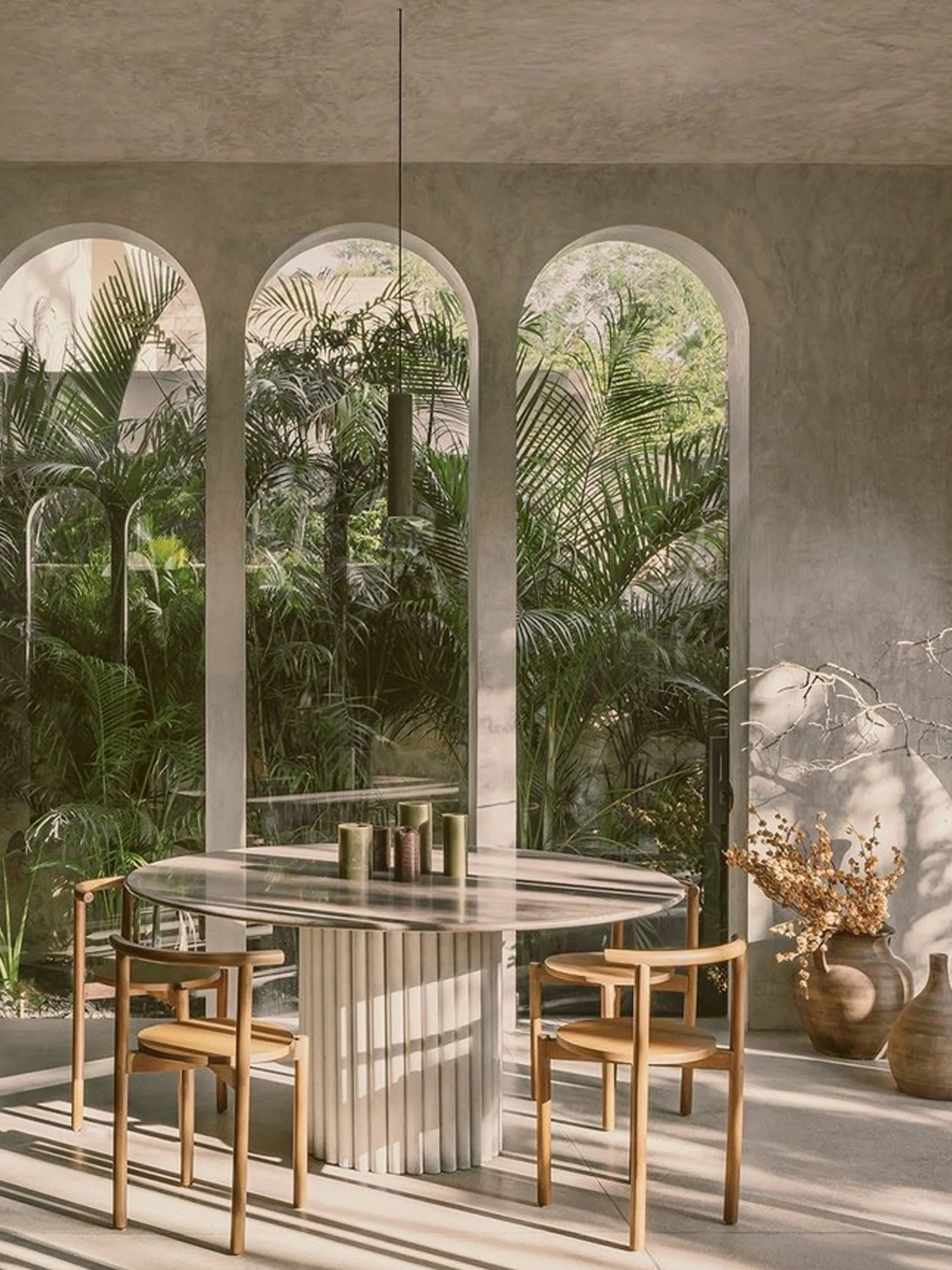 Dining room surrounded by greenery, visible through arched openings.