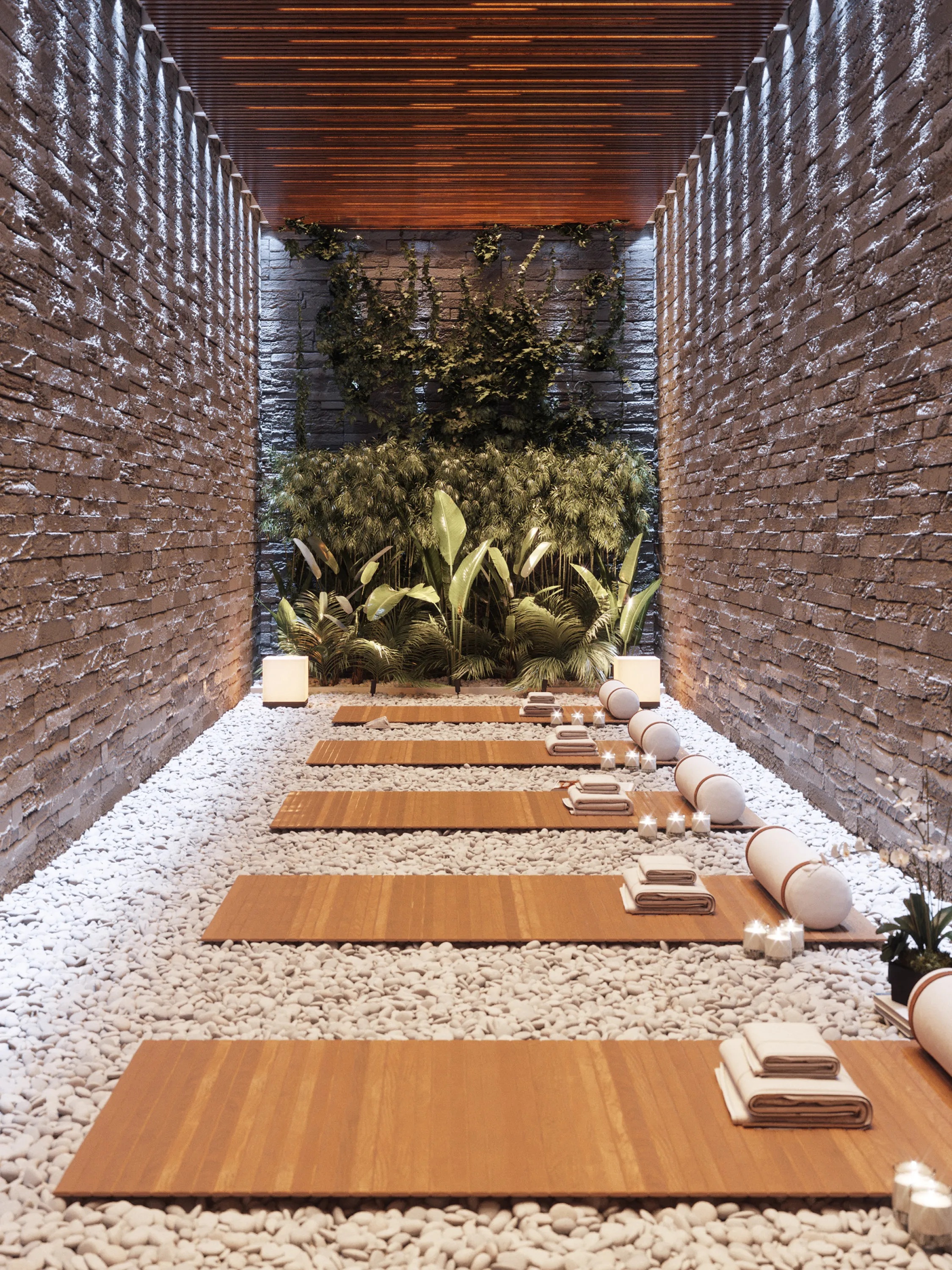 Meditation room with a green wall feature, stone walls and little pebbles on the ground.
