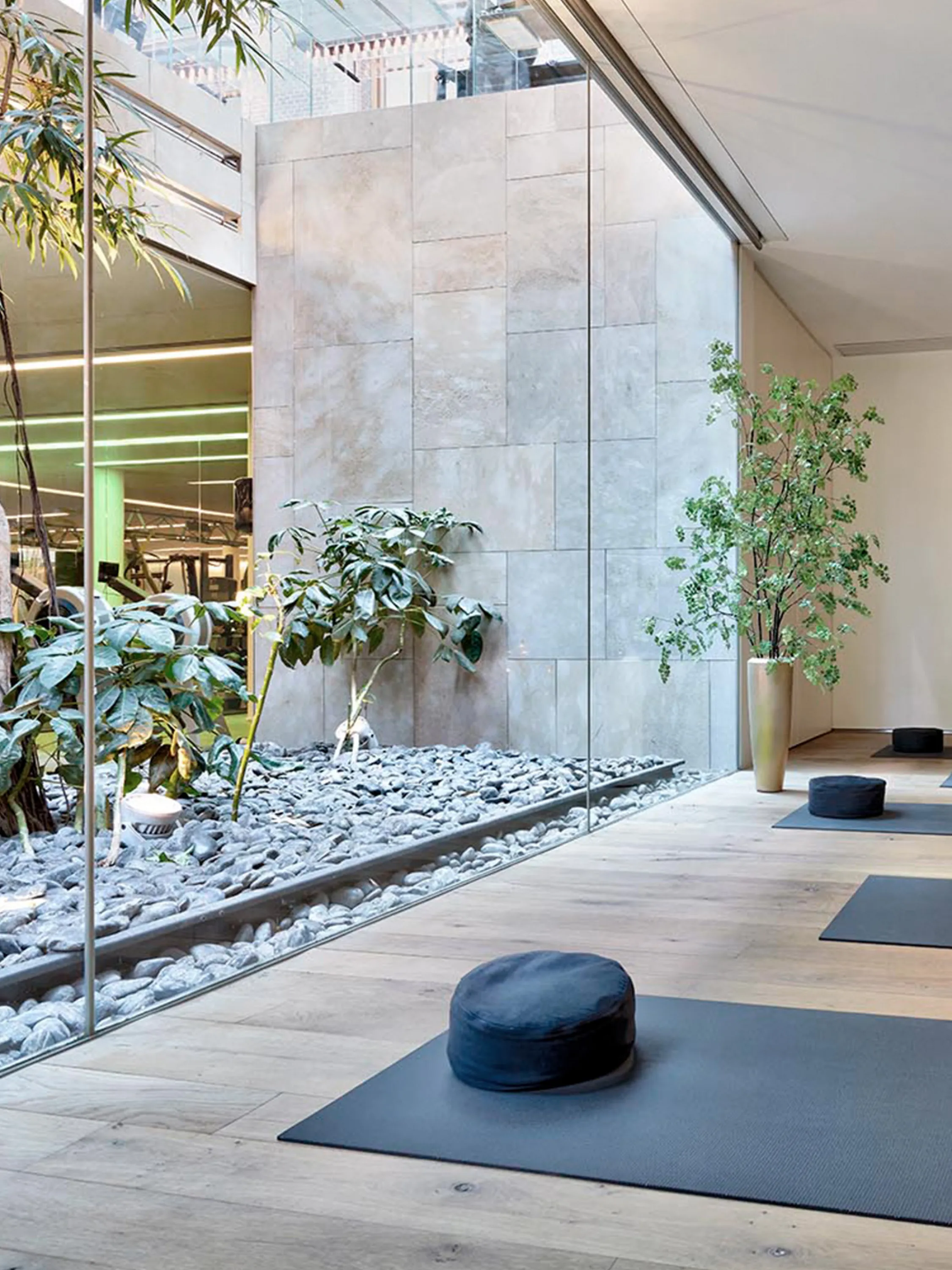 Meditation room with a full-height window looking into a patio rich in greenery.
