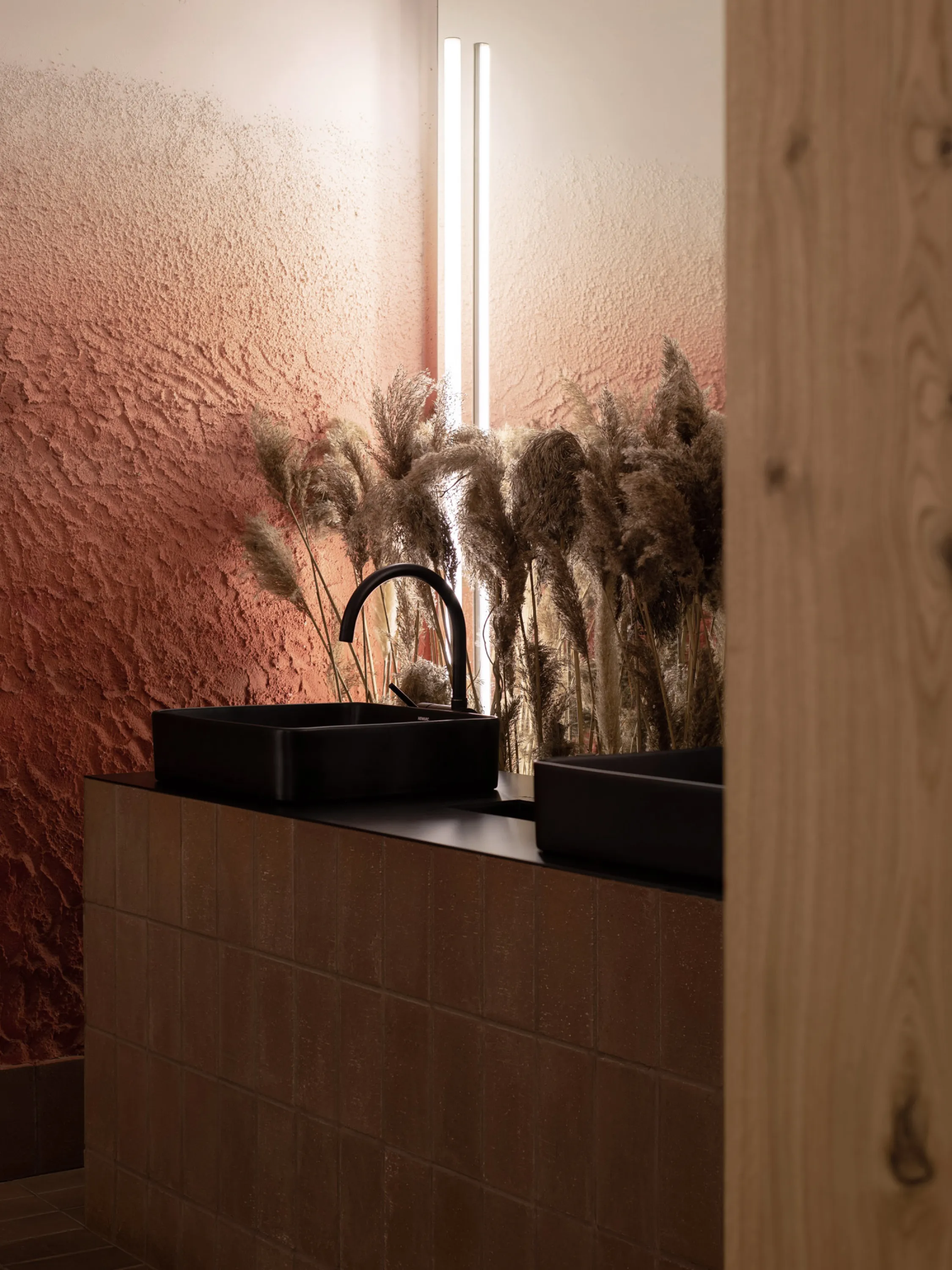 Bathroom with textured wall and touchable greenery.