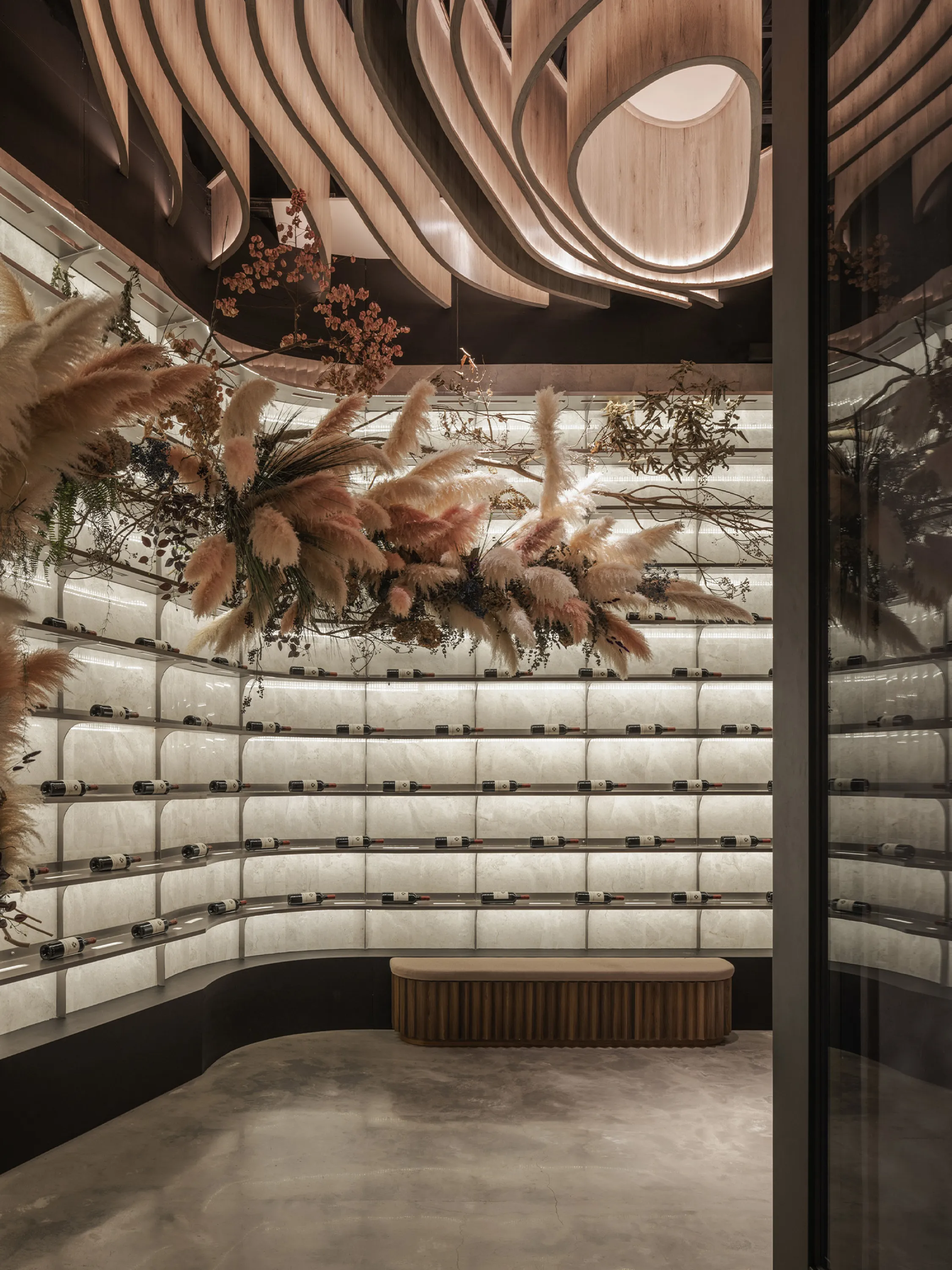 Wine display area with a pampas grass composition hanging from the ceiling.