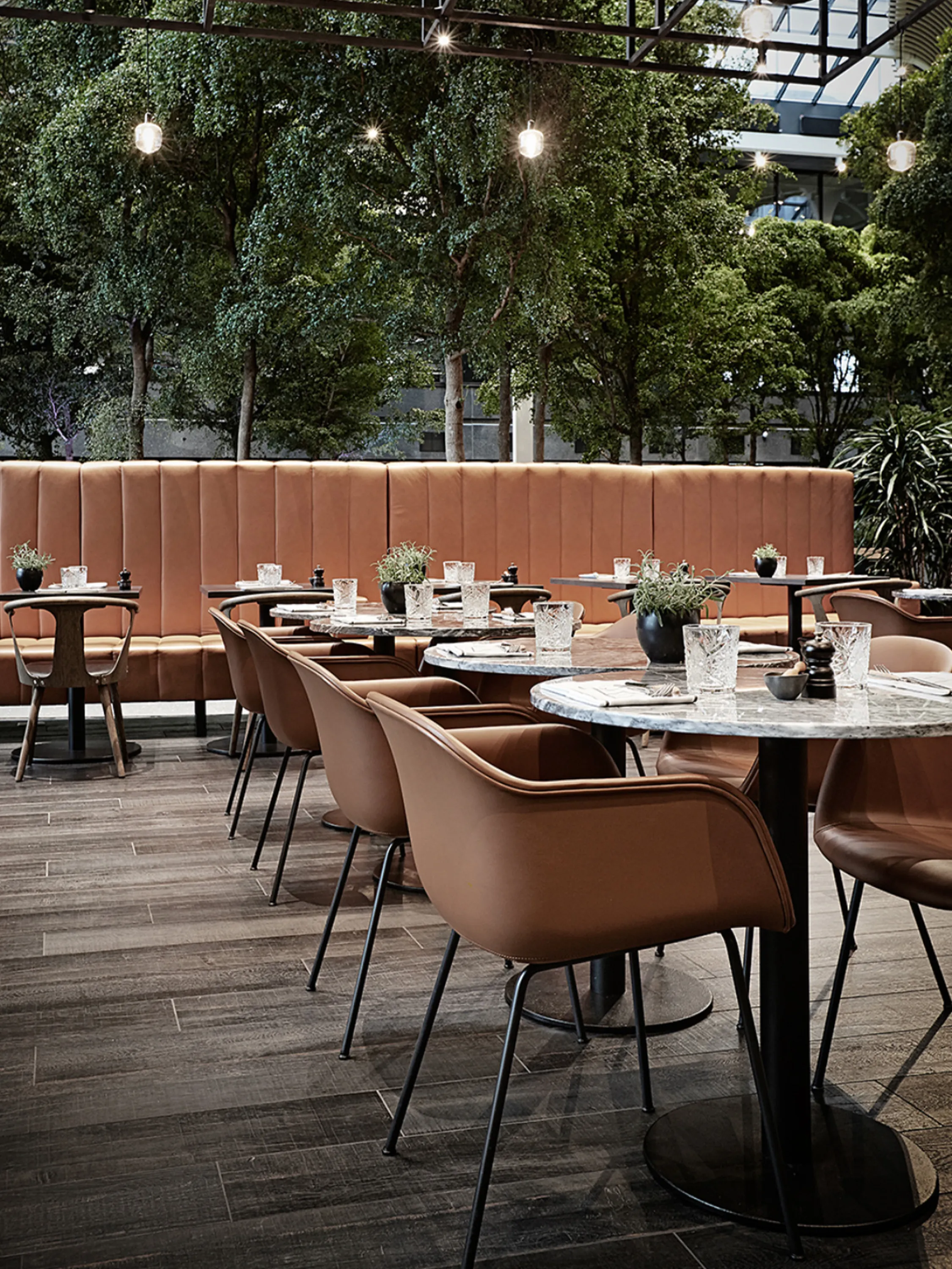 Restaurant space looking into a lush planted indoor garden.