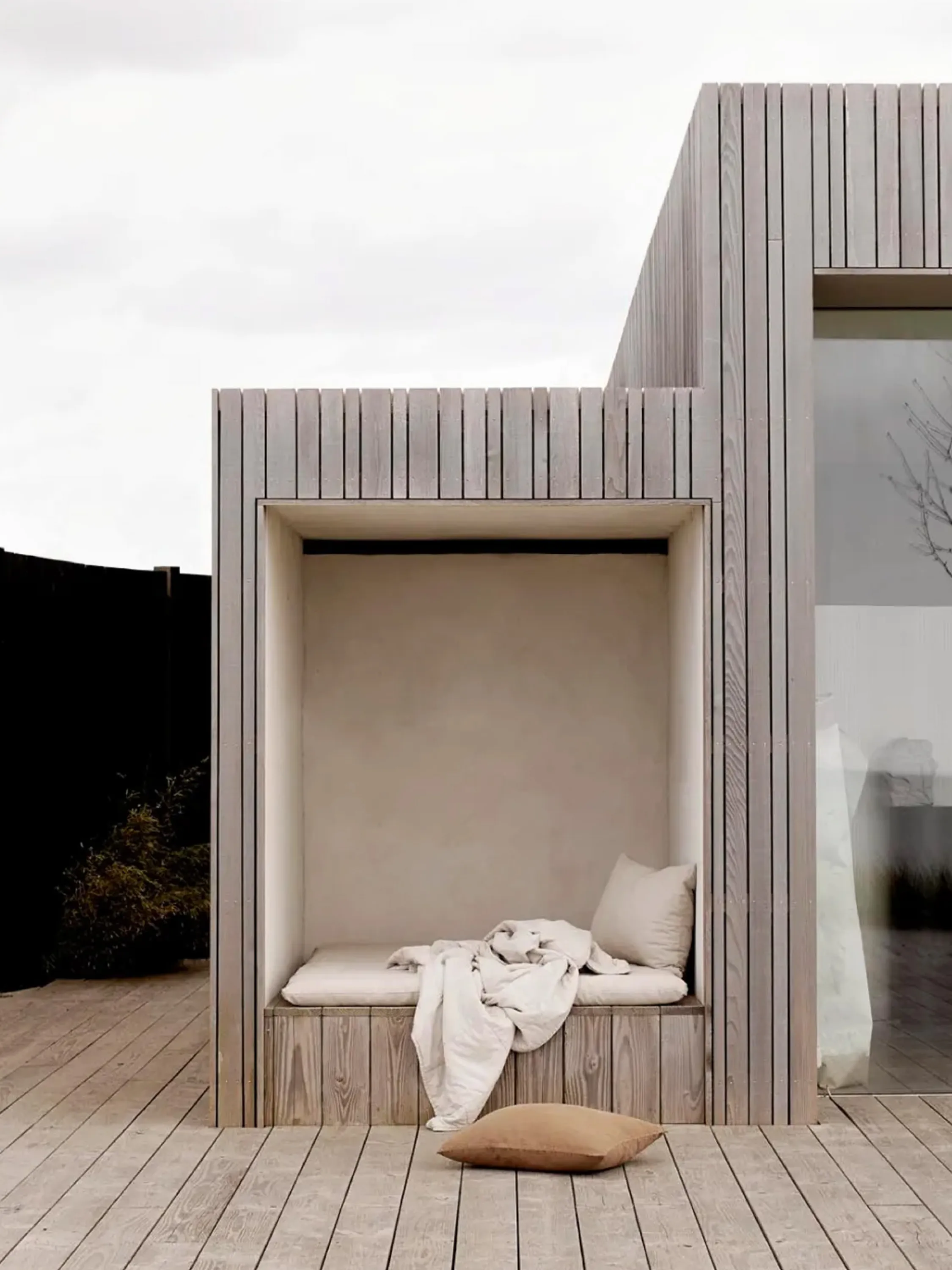 Outdoor space with blanket and cushions.