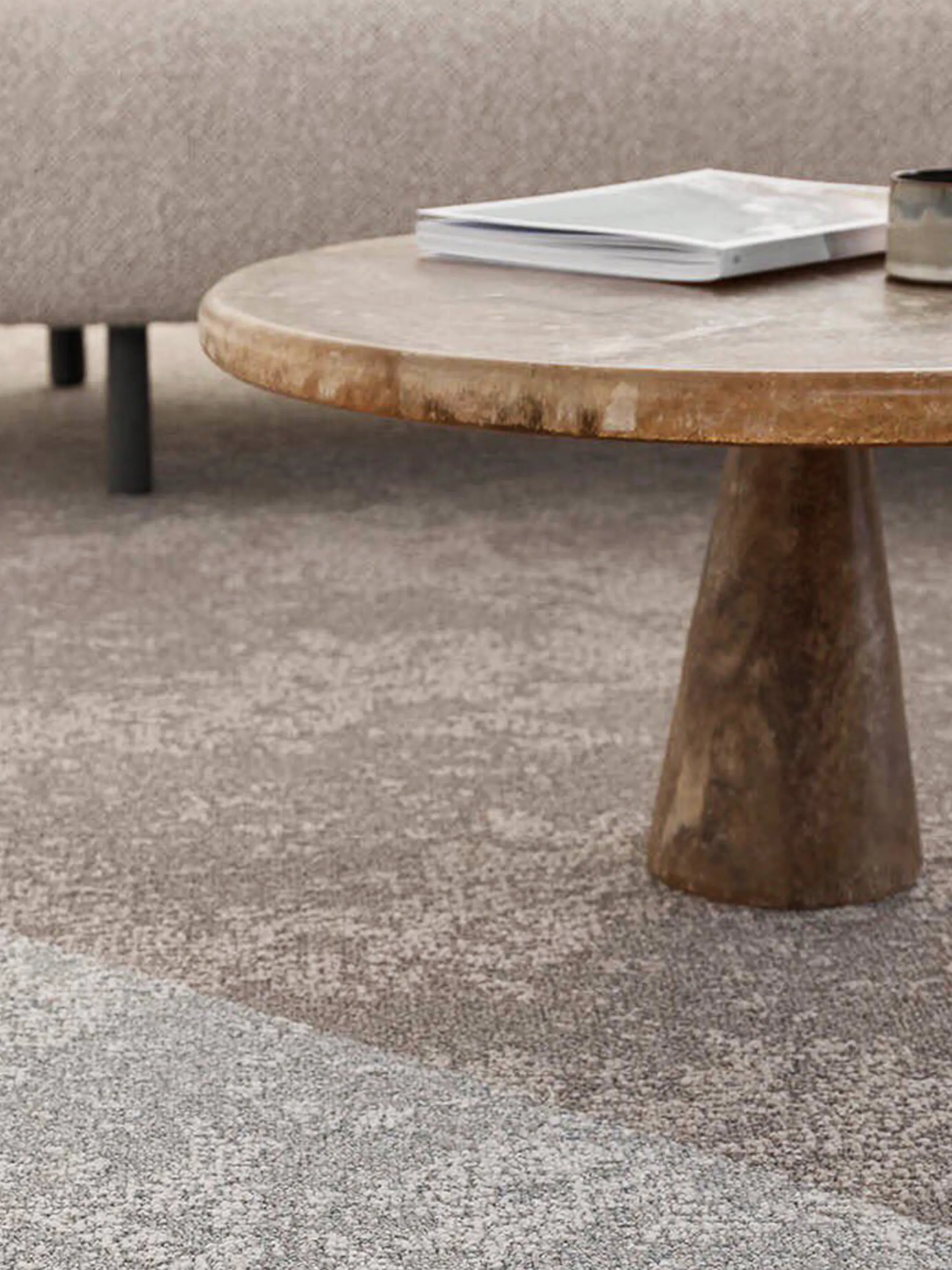 Close-up of a stone side table on a carpet.