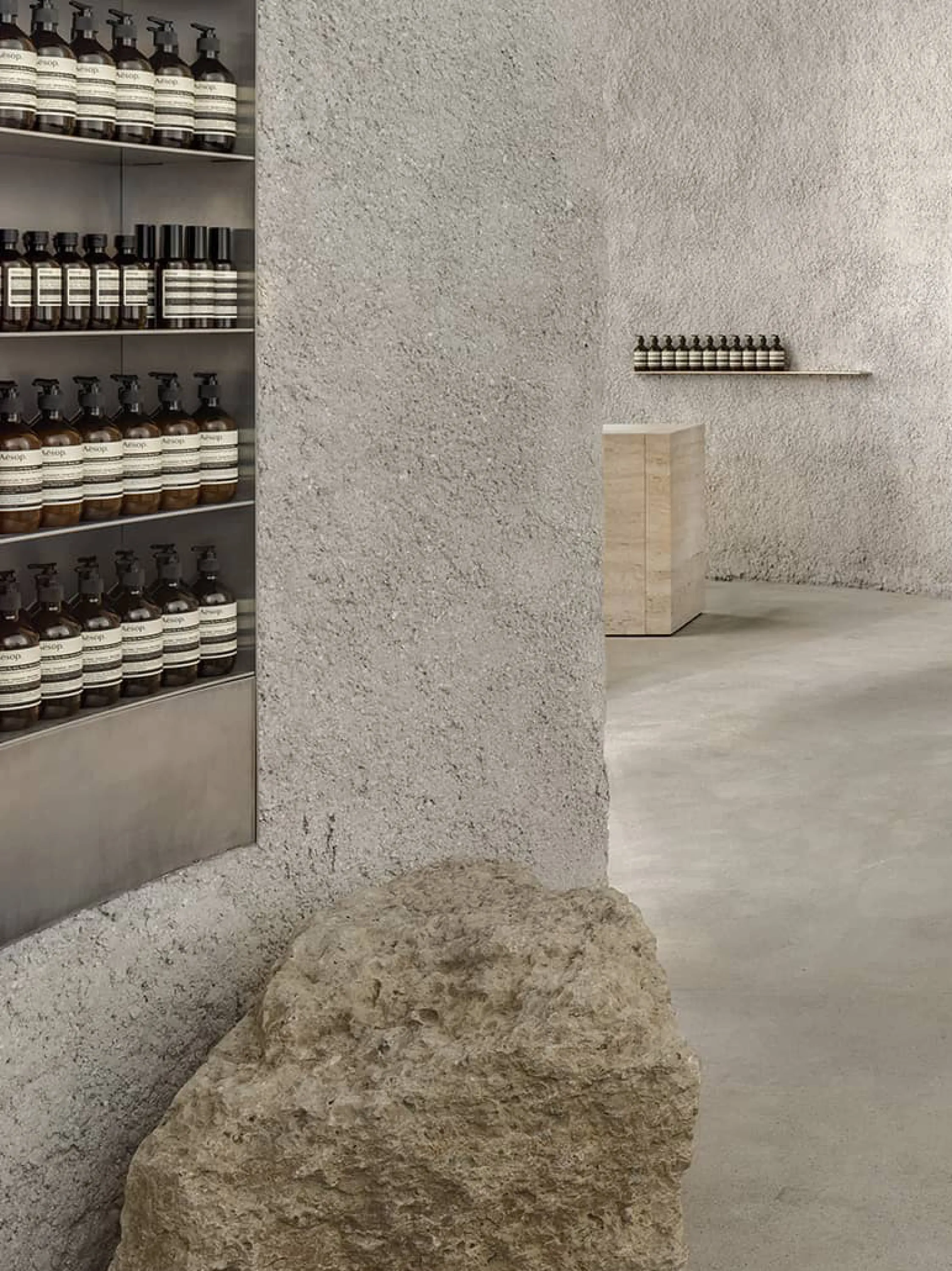 Cave-like store with rough stone surfaces recalling local ecology.