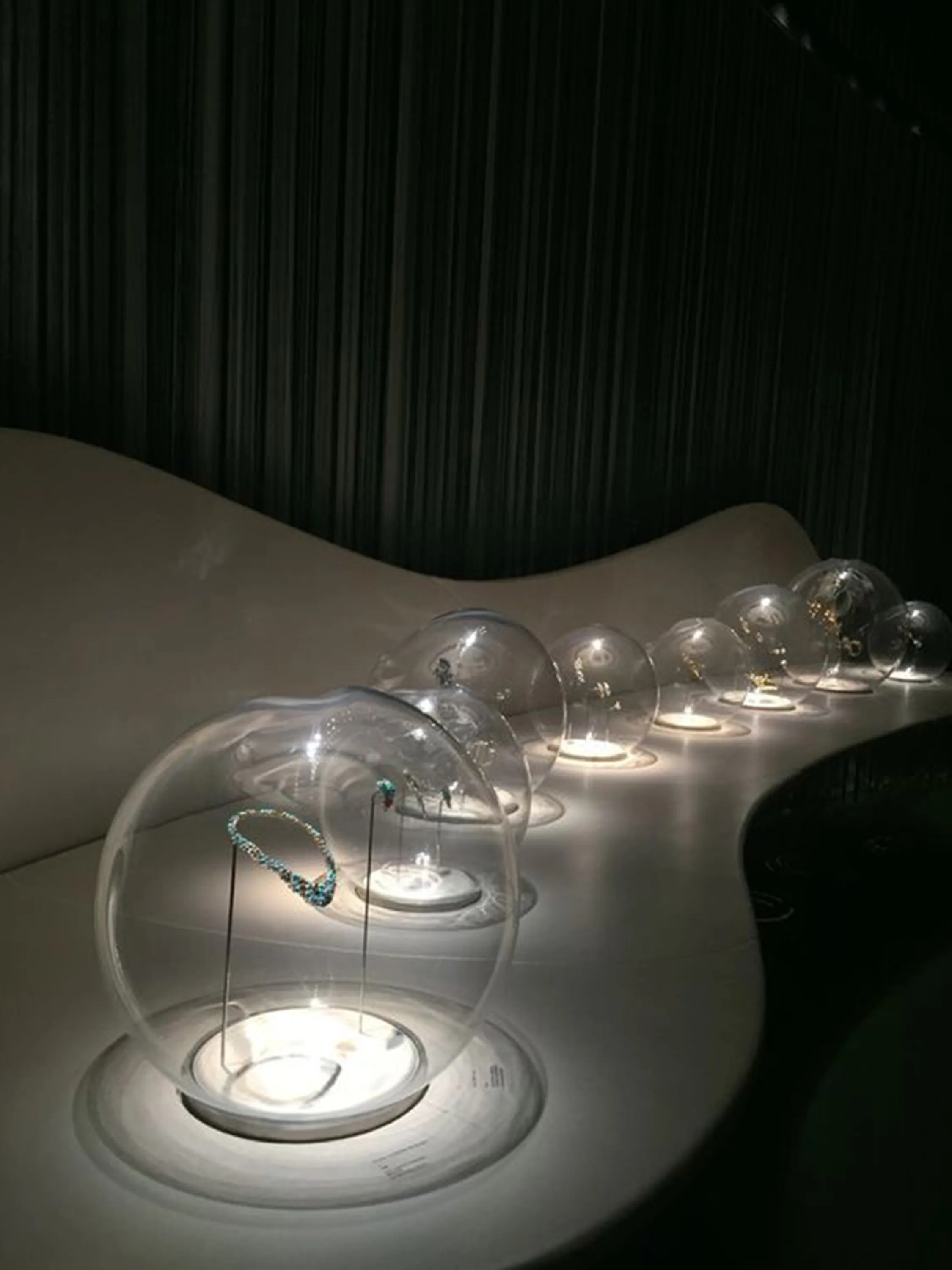 Jewels exposed into baubles being the only lit elements in the space.
