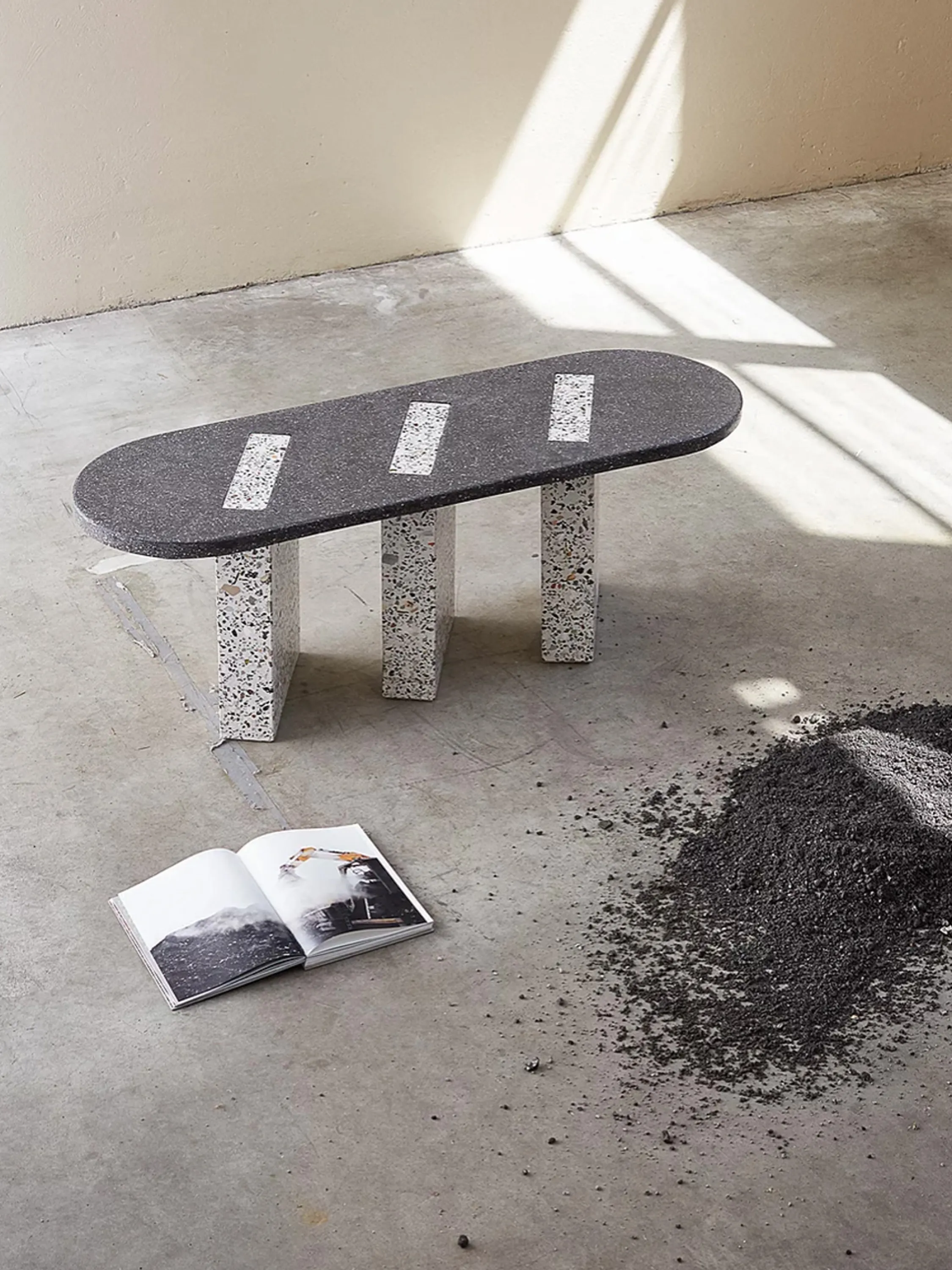 Three-leg bench next to a pile of bottom ash.