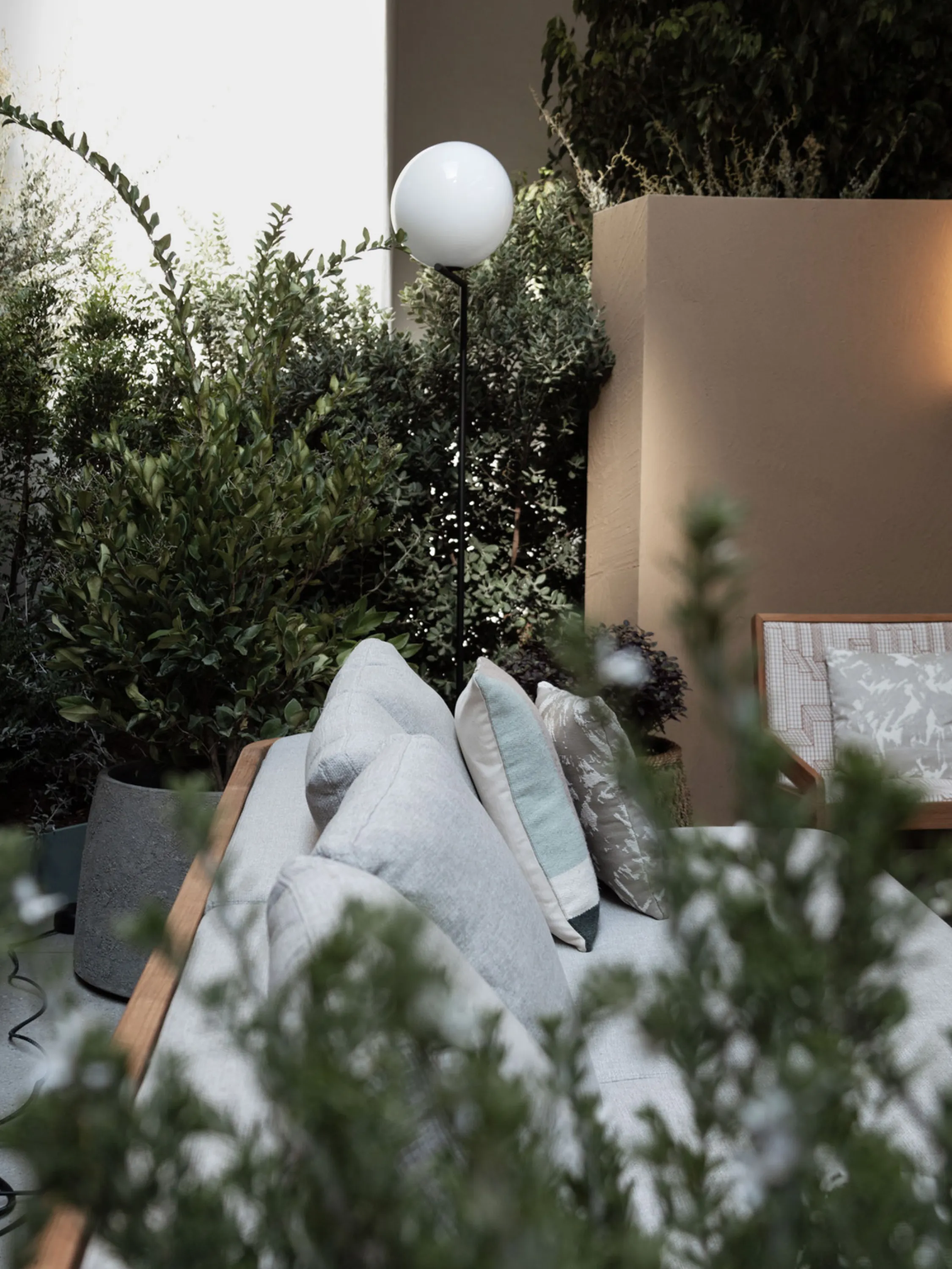 Close-up: a sofa peeking through plants.