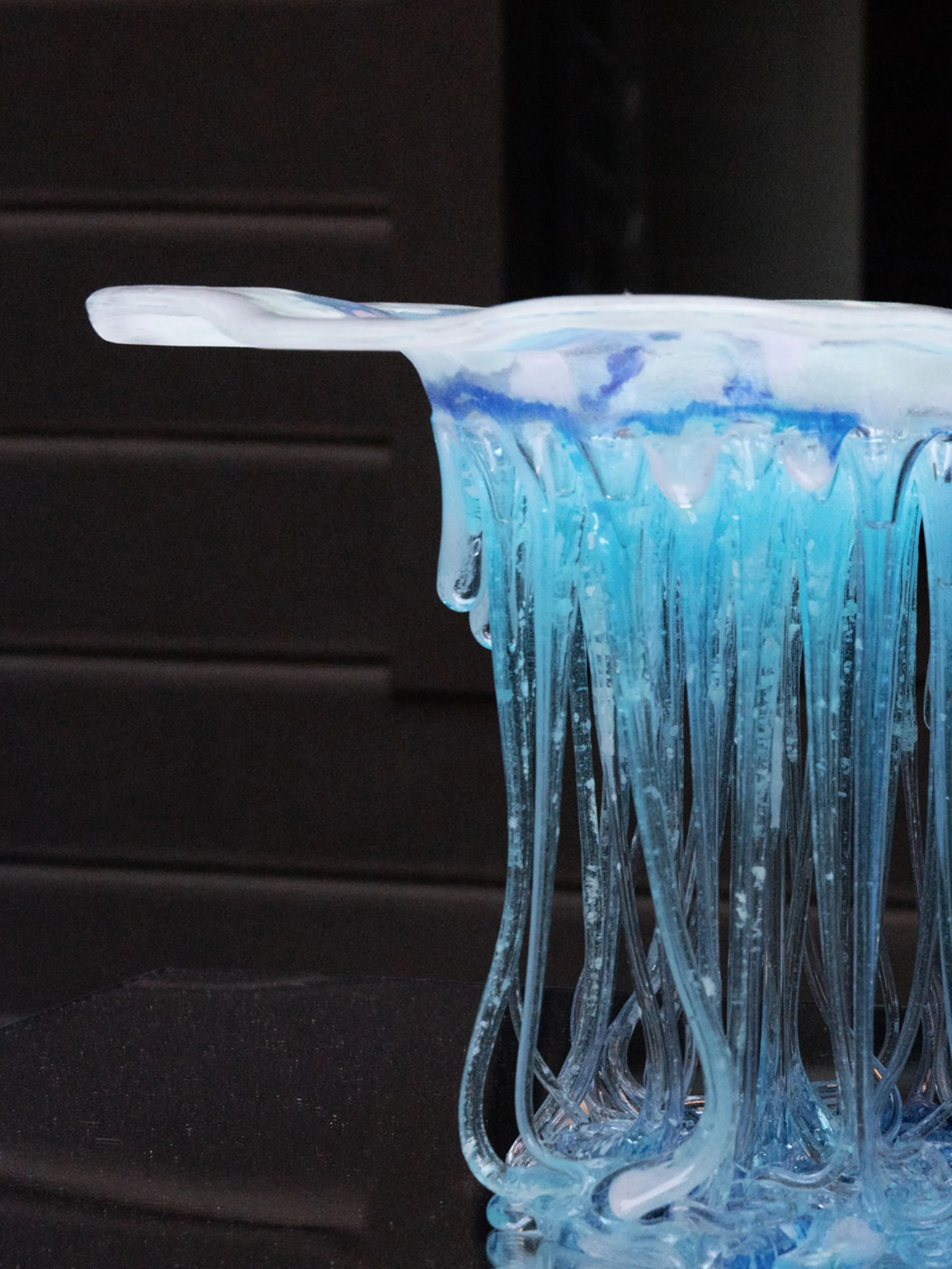 Glass side table with a flowy shape.