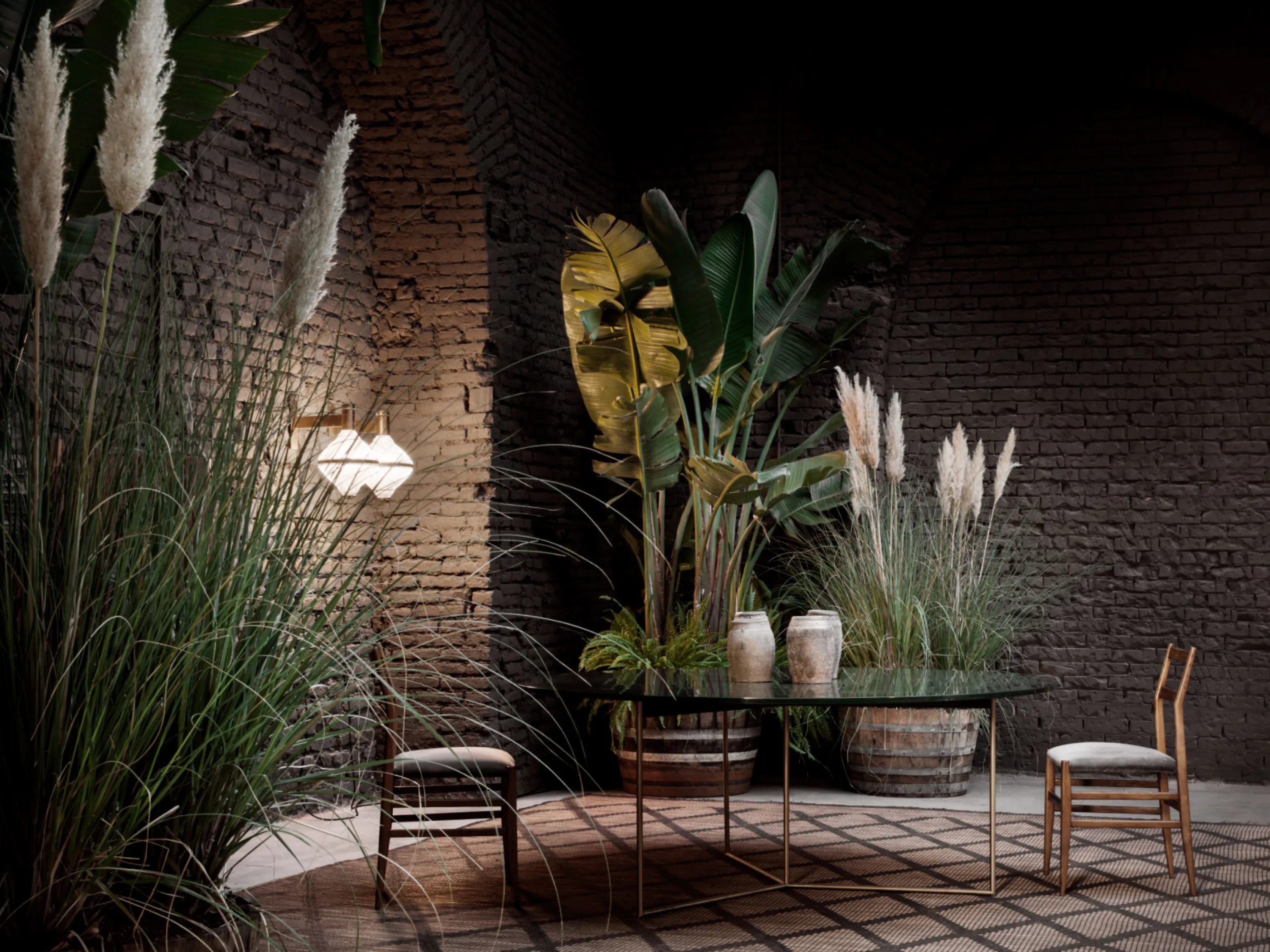 Moody dining area enclosed by tall plants.