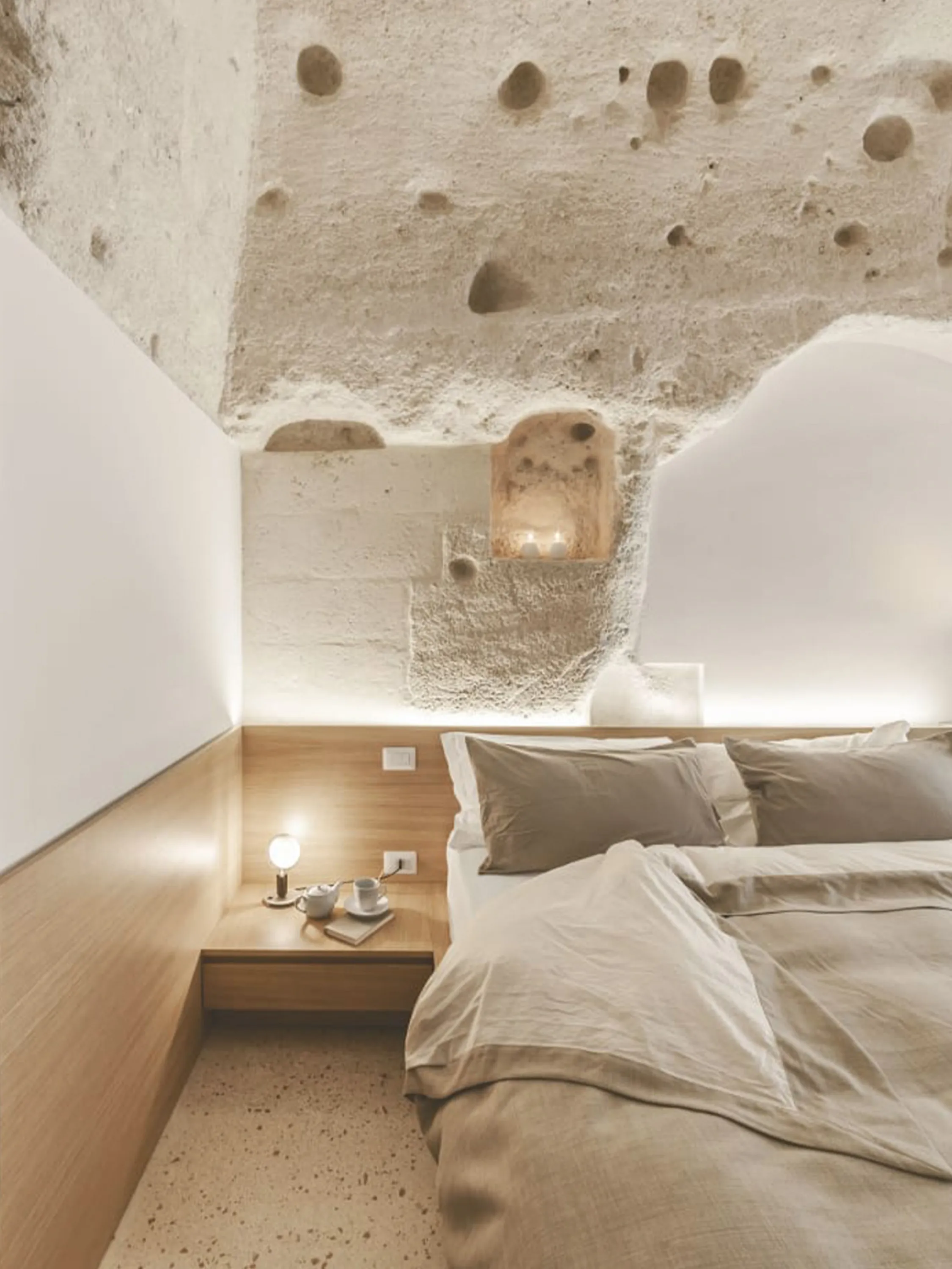Contemporary bedroom built in a traditional building with raw stone walls.