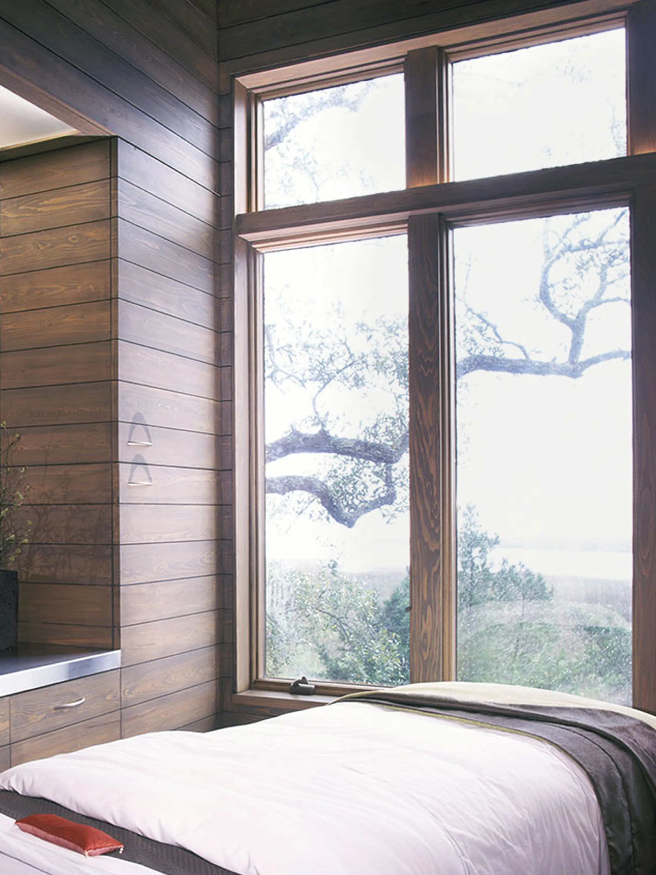 Bed positioned in front of a green view.