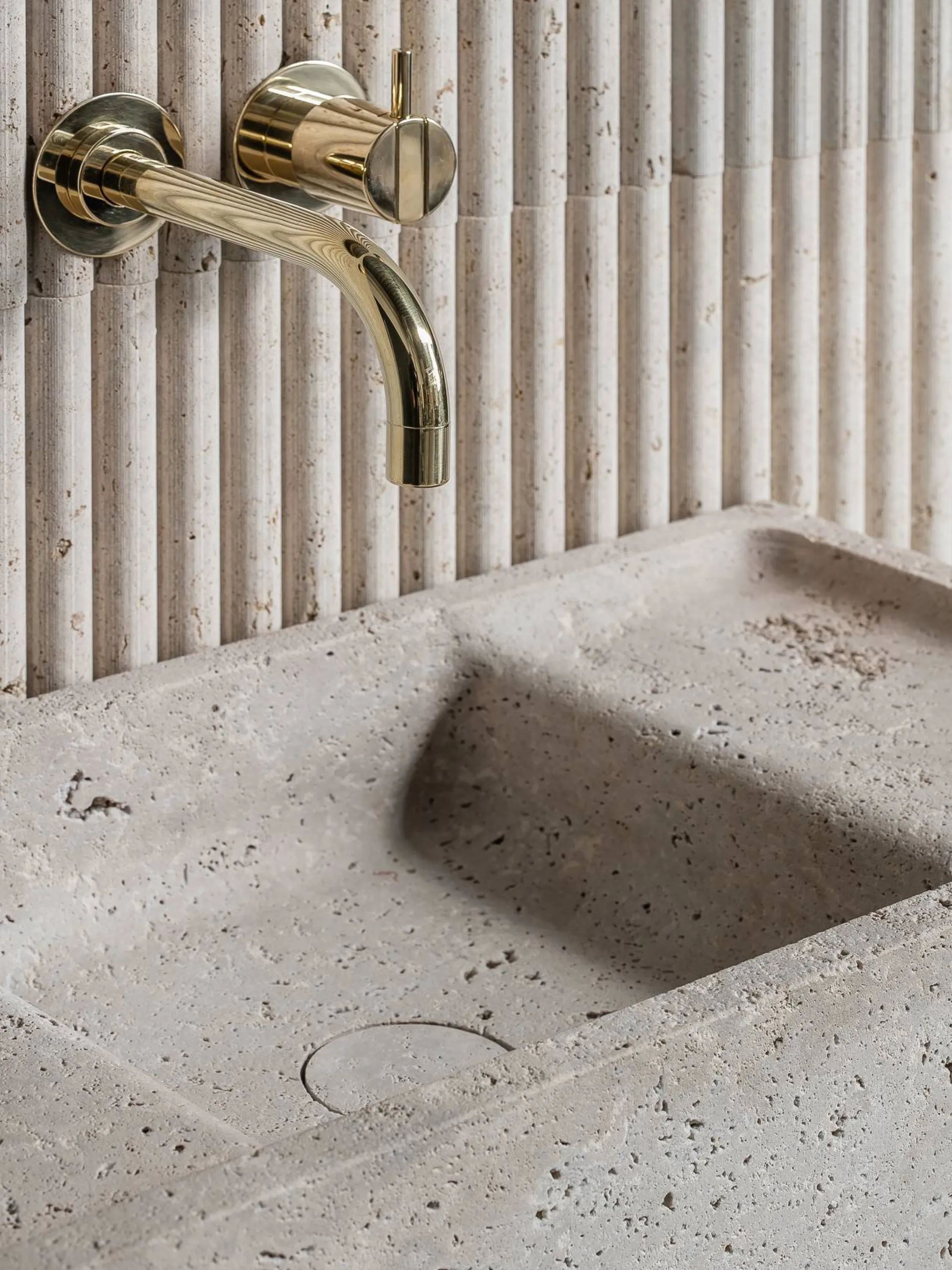 Stone basin with matching fluted wall.