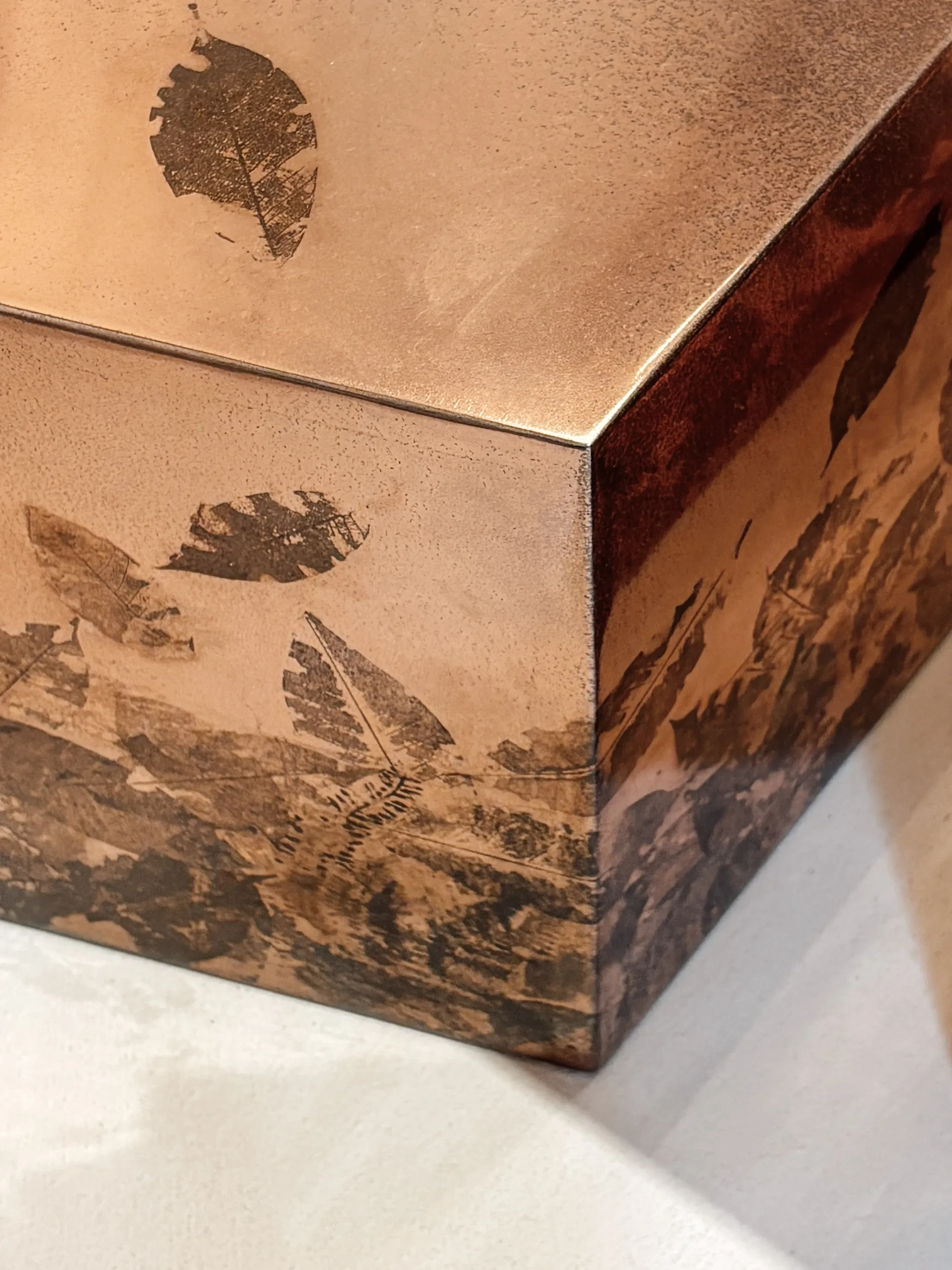 Metal table with leaf imprints.