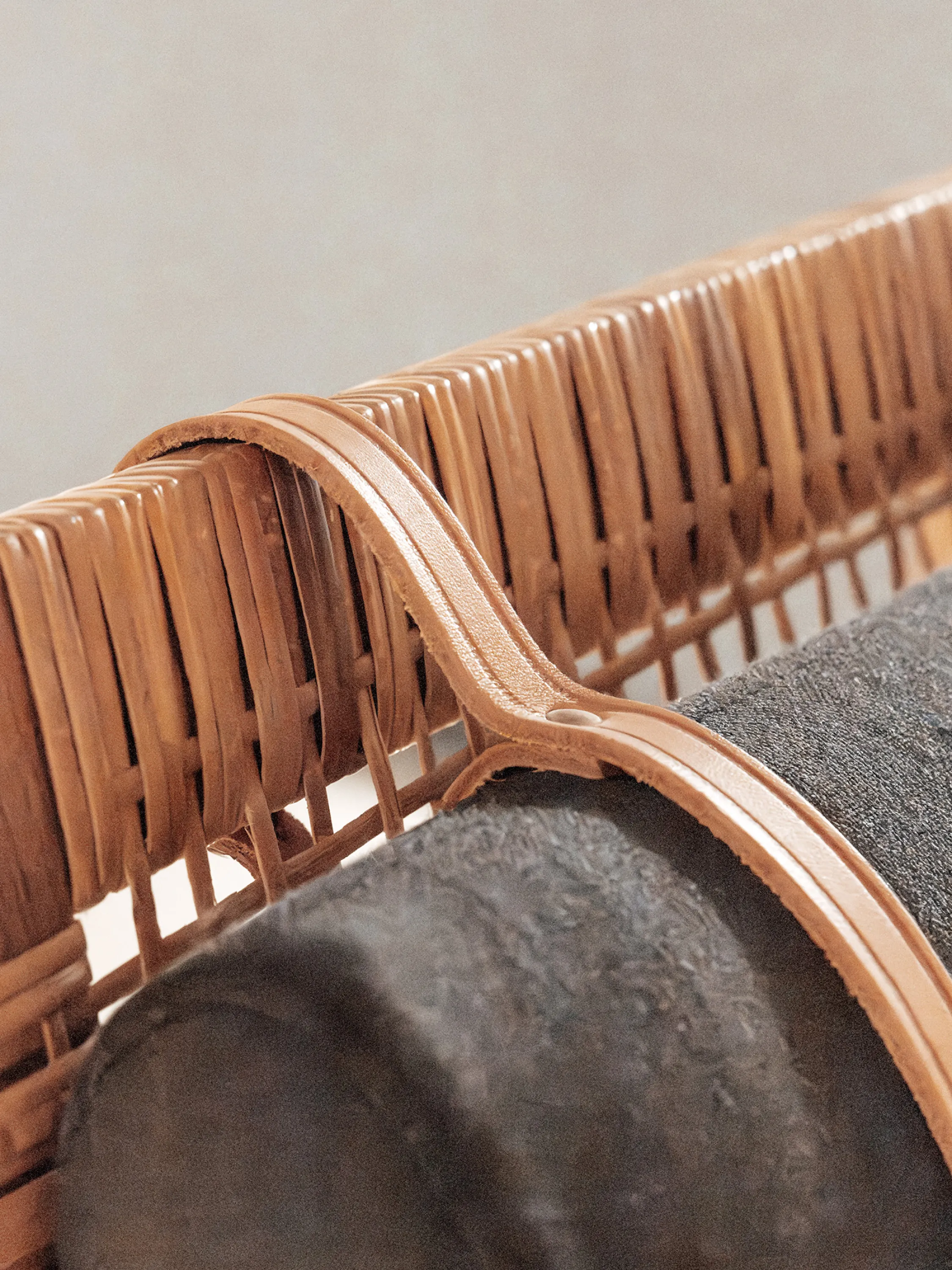Detail of a leather strap holding an armchair's head cushion.