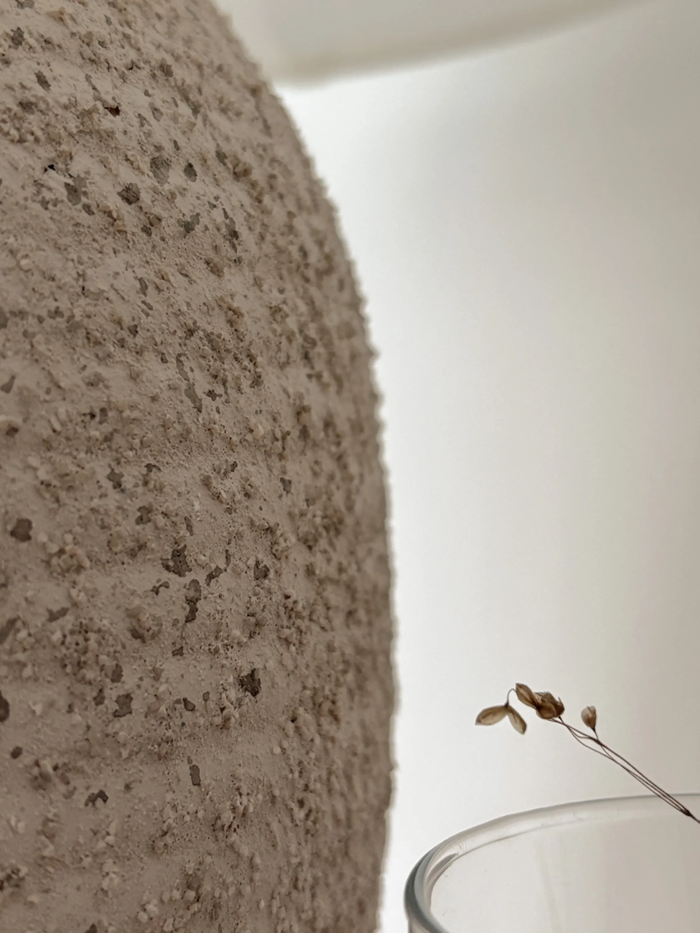 Textured lamp contrasting with a smooth wall.