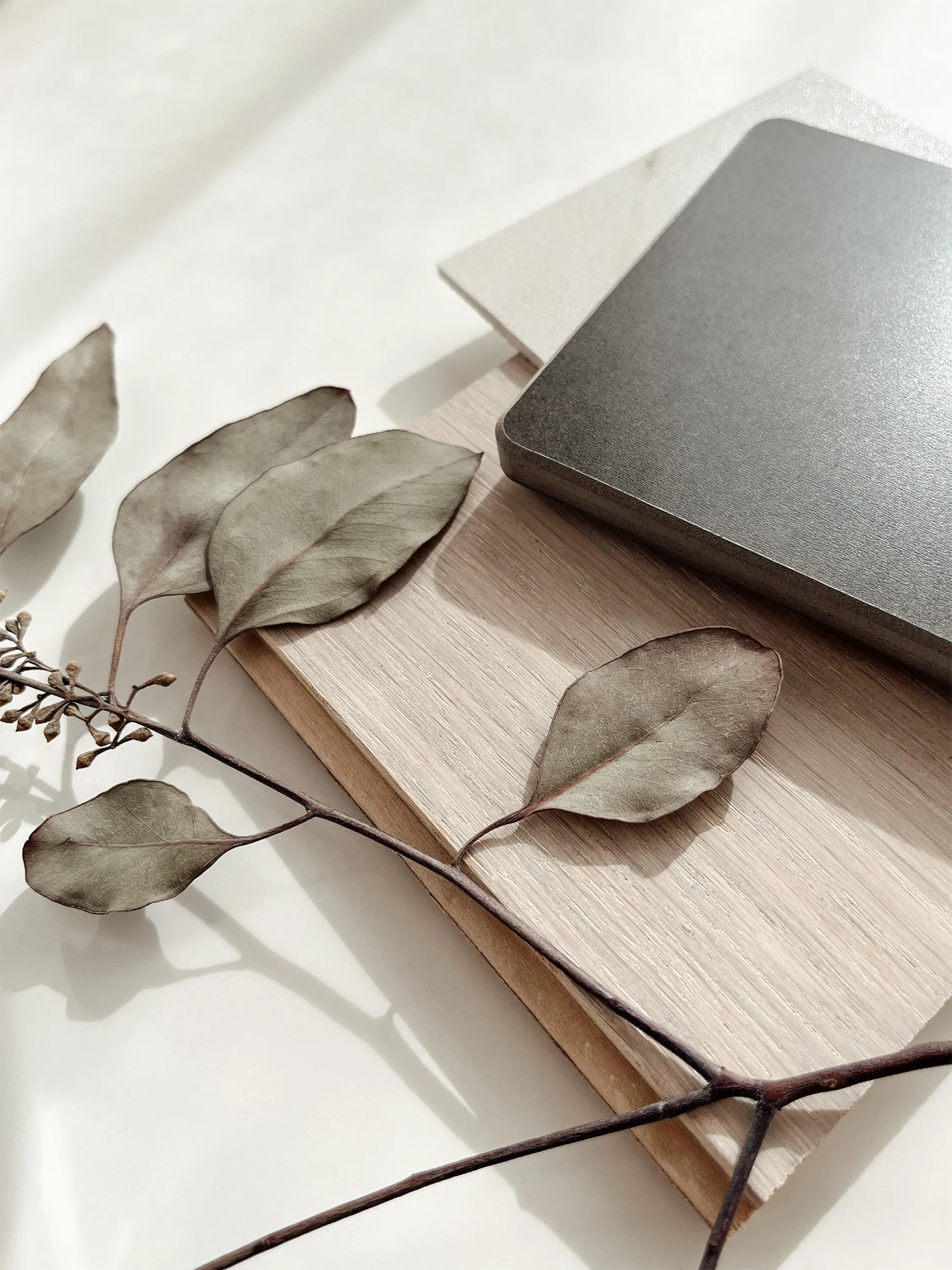 A material board with real greenery and tactile material samples.